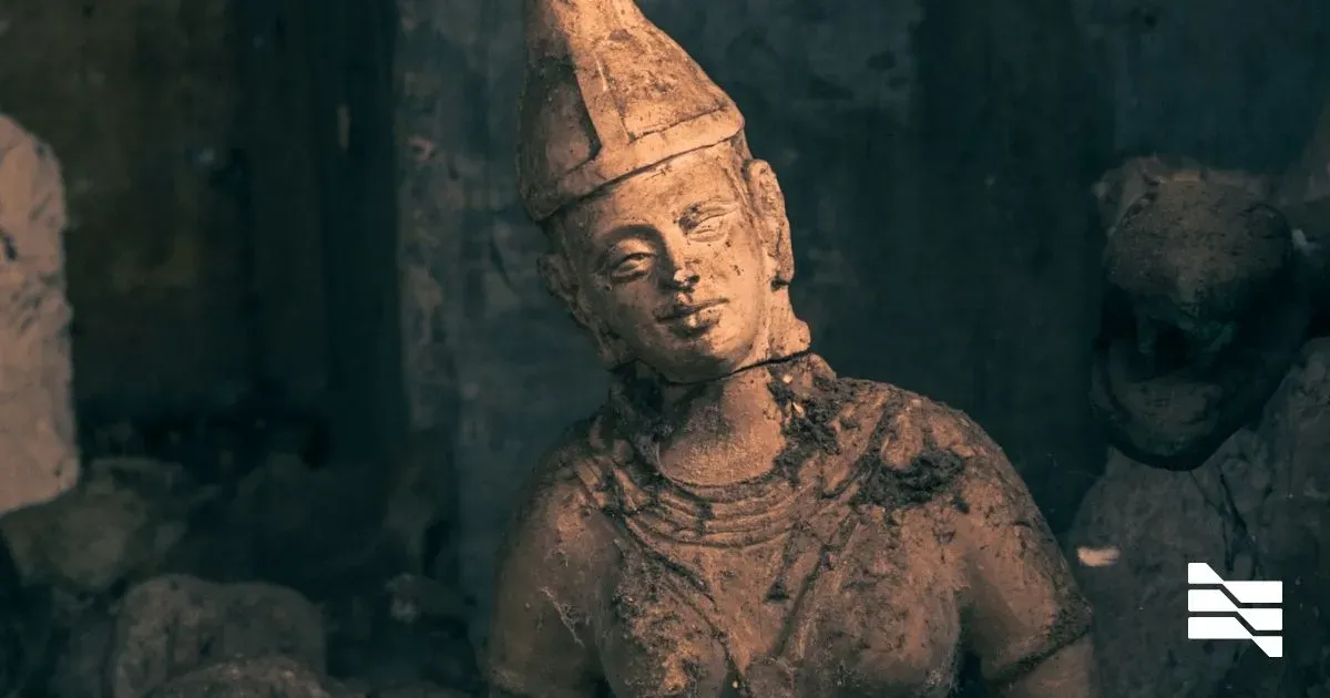 An ancient terracotta sculpture of a serene-looking Buddhist figure, symbolizing the negotiation of harmony in payment terms between freelancers and clients.